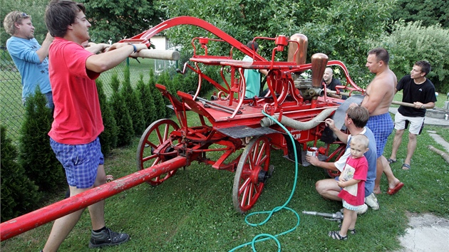 Hasiči i dobrovolníci v Šarovech čistí historickou stříkačku. Hasiči i dobrovolníci v Šarovech čistí historickou stříkačku.