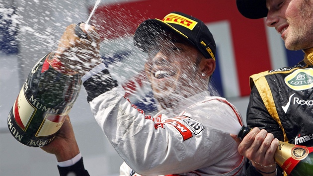 Lewis Hamilton (vlevo) si uv vtzstv ve Velk cen Maarska. Sprchuje ho Romain Grosjean.