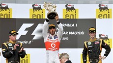 TROFEJ PRO VÍTZE. Lewis Hamilton si uívá vítzství ve Velké cen Maarska,