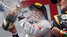 Lewis Hamilton (vlevo) si uívá vítzství ve Velké cen Maarska. Sprchuje ho