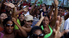 Kubánci tancují na oslavách revoluce ped portrétem Fidelem a Raúlem Castrem
