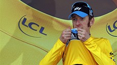LUTÝ. Bradley Wiggins líbá lutý dres pro nejlepího závodníka Tour de France.