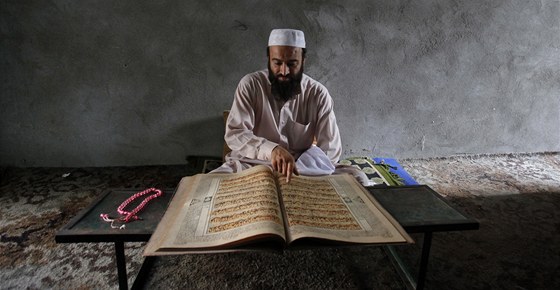 Muslimský vící z pákistánského Peáváru si bhem ramadánu te v Koránu (29.