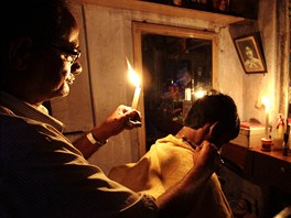 TMA NEVADÍ. Indický holi z Kalkaty drí v jedné ruce svíku a druhou stíhá...