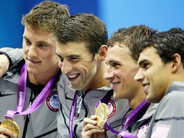 Michael Phelps (druh zleva) v tmu americkch plavc, je zskal ve tafet na