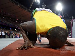 ZLATÝ POLIBEK. Jamajský sprinter Usain Bolt líbá místo, kde obhájil zlato v...