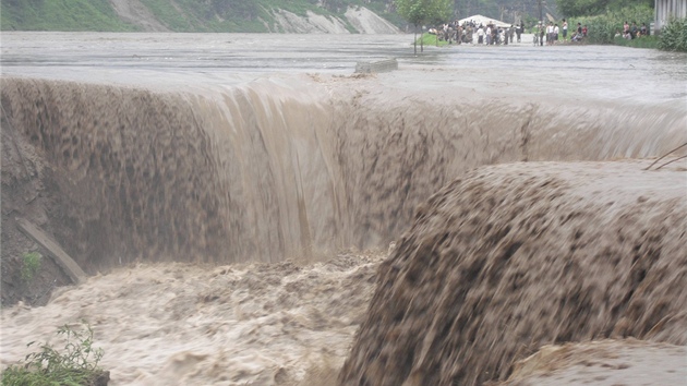 Severn Korejci zpovzdl sleduj podemletou silnici, kterou zniily rozshl zplavy.