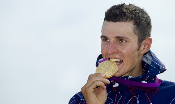 NEMÁTE OTVÍRÁK? eský biker Jaroslav Kulhavý si zlatou olympijskou medailí po závod otevel pivo.