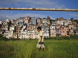 MEZI NEBEM A ZEMÍ. Nepálský chlapec se brouzdá travou na zarostlém fotbalovém...