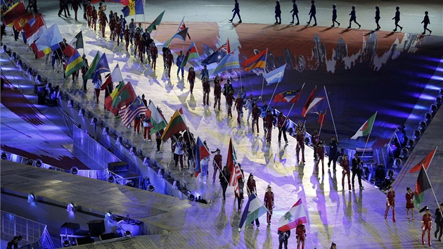 VECHNY ZEM POHROMAD. Na plochu stadionu nastupuj sportovci s vlajkami svch