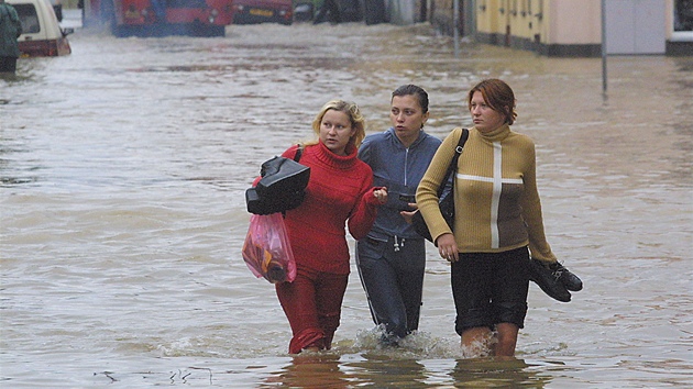 Dívky se brodí zatopenými ulicemi v plzeské tvrti Roudná. Ta pi povodni v