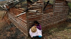 Kolumbijská indiánka kojí dít ped chatrí znienou v bojích mezi vládními