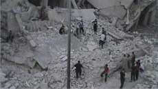 Zábr ukazuje obyvatele ped zdemolovaným domem v Homsu (11. srpna 2012)
