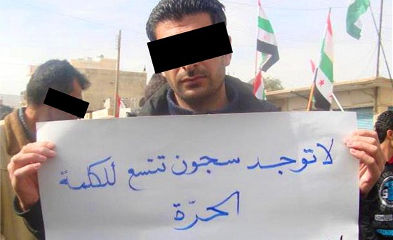 Syrský noviná jet v Qámilí drí nápis "Není vzení, které by uvznilo