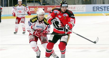 Znojemský hokejista Jan Lattner v souboji s protihráem z Klagenfurtu.