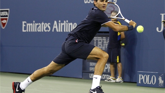 JET KOUSEK. Roger Federer dosahuje mek ve tvrtfinle US Open proti Tomi Berdychovi.