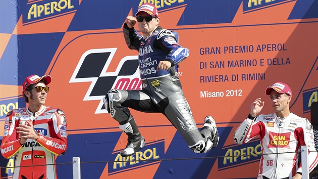 JE MU DO SKOKU. Jorge Lorenzo na stupnch vtz slav vtzstv ve Velk cen San Marina, pihlej druh Valentino Rossi a tet Alvaro Bautista.