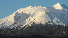 Jezero dole je obklopené zelení, ledovec nahoe na vulkánu Osorno se na slunci...