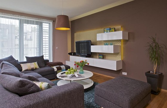 Obývacímu pokoji dominuje velká sedací souprava ve tvaru L s taburetem. Skíky