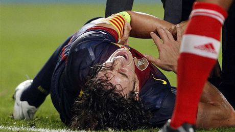 Barcelonský kapitán Carles Puyol se svíjí v bolestech. Vykloubený loket ho v