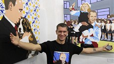 Umlec Alexej Sergjenko stojí ped svými obrazy  pi otevení jeho výstavy
