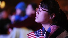 Mladá Amerianka sleduje na obí obrazovce v Denveru první prezidentskou