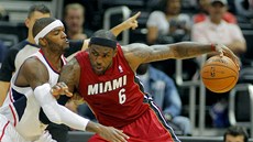 LeBron James (vpravo) z Miami se tlaí do Joshe Smithe z Atlanty.