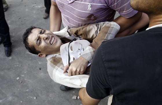 Zranného odprce Muslimského bratrstva museli z námstí Tahrír lidé odnést v...