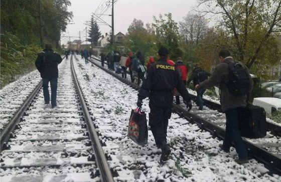 Cestující z vlaku, který uvázl u Nelahozevsi, jdou k nejbliímu nádraí (27.