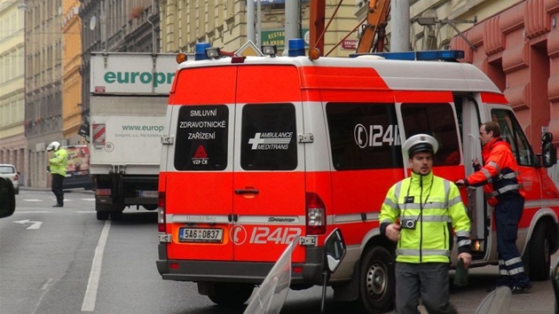 Stet nkladnho auta a vozu s vysokozdvinou ploinou na Plzesk ulici v Praze.