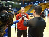 Trenr basketbalovho Nymburka Ronen Ginzburg poskytuje v hale Hapoelu rozhovor
