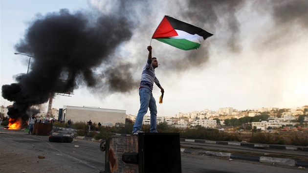 Mu s vlajkou Palestiny protestuje proti izraelskmu bombardovn Gazy ve mst Ofer. (18. listopadu 2012)