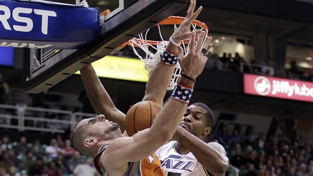 Derrick Favors v blm dresu Utahu blokuje Marcina Gortata z Phoenixu.