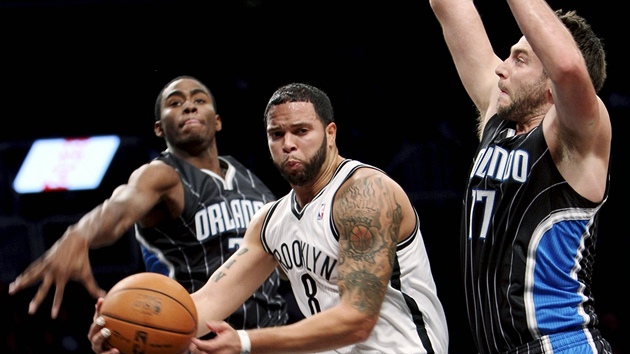 Deron Williams (v blm) z Brooklynu pronik mezi Joshem McRobertsem (vpravo) a Moem Harklessem z Orlanda.