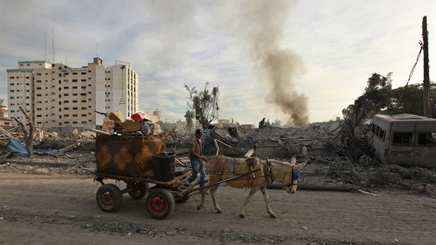 Palestinec se svm vozkem projd kolem trosek budov zniench pi izraelskm ostelovn Psma Gazy  (21. listopadu 2012)