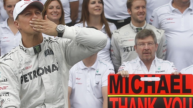 LOUEN S TMEM. Michael Schumacher pzuje s tmem Mercedes ped svm poslednm zvodem ve formuli 1. Vpravo s cedul sed f stje Ross Brawn.