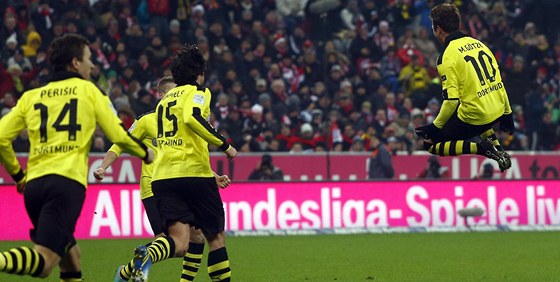 STELEC VE VZDUCHU. Fotbalisté Dortmundu se sbíhají k Mariovi Götzemu (vpravo),...