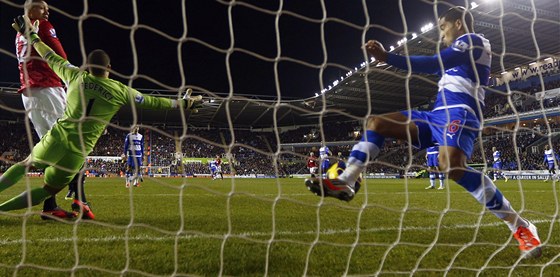 GOL, NEGÓL Obránce Adrian Mariappa z Readingu vykopává stelu Robin van Persie