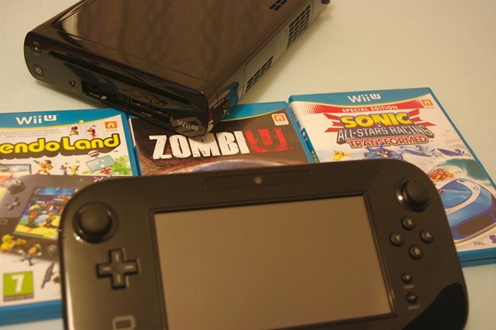 V pozadí konzole Wii U, v popedí tablet. Dominantou obal od her je modrá...