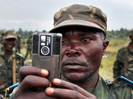 MÍSTO STÍLENÍ FOTÍME. Jeden ze len jednotek FARDC si fotografuje vesniku...