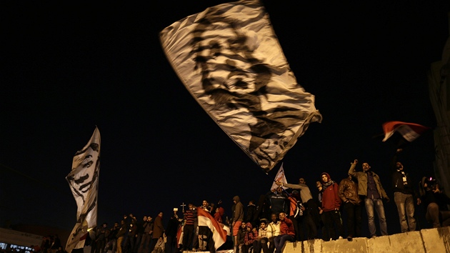 Protestanti ped prezidentskm palcem v Khie mvaj prapory a egyptskmi vlajkami. (11. prosince 2012)