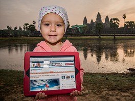 Malá Ella drí tablet s otevenou stránkou iDNES.cz pi východu slunce u...