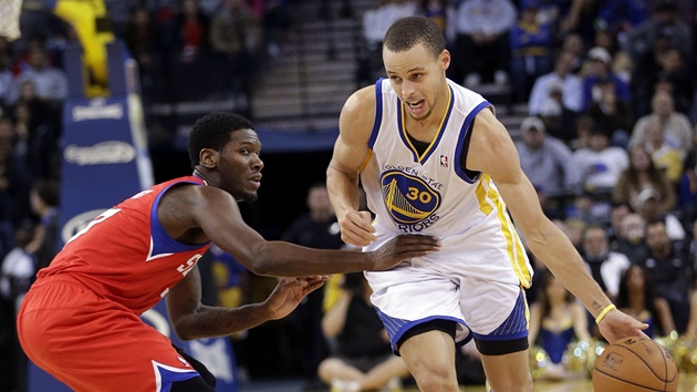 Stephen Curry (vpravo) z Golden State obchz Jrue Holidaye z Philadelphie.