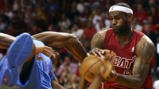 LeBron James (vpravo) z Miami a Serge Ibaka z Oklahoma City v tvrdém souboji o LeBron James (vpravo) z Miami a Serge Ibaka z Oklahoma City v tvrdém souboji o
