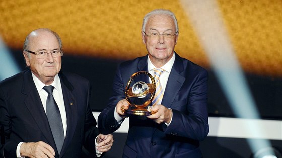 Franz Beckenbauer (vpravo) pebírá ocenní z rukou Seppa Blattera, Momentka z roku 2013.