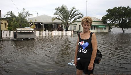 Australanka Cheryl McDowellová stojí pes svým zaplaveným domem v Bundabergu.