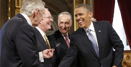 Barack Obama tese pravicí Harrymu Reidovi. Ten v druhé ruce drí pero, které...