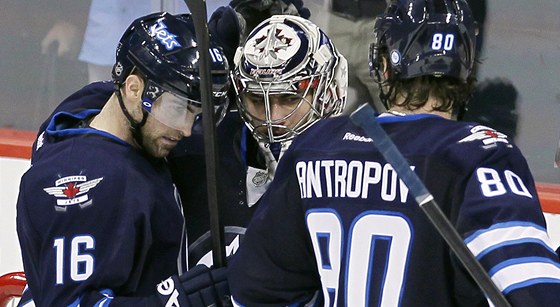 Branká Ondej Pavelec (uprosted) pijí gratulace ke svému výkonu od