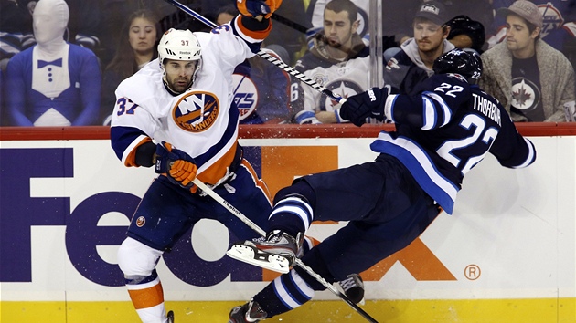 Brian Strait (vlevo) z New York Islanders prv srazil Chrise Thorburna z Winnipegu.