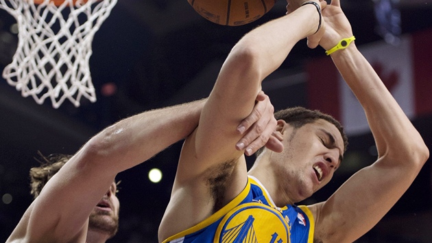 Klay Thompson (vpravo) z Golden State po faulu Aarona Graye z Toronta.